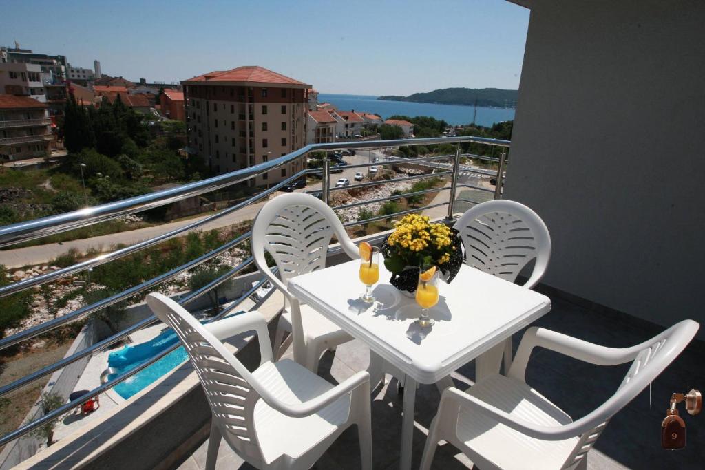 a white table with chairs and flowers on a balcony at Villa Andjelina in Budva