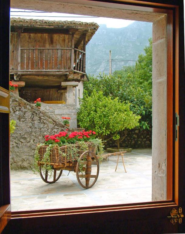 a bike with flowers in a basket outside a window at Hotel Aldama Golf in Quintana de Llanes