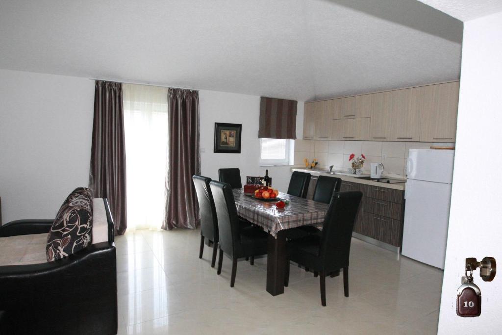 a kitchen and dining room with a table and chairs at Villa Andjelina in Budva
