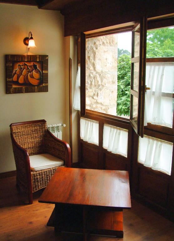 a room with a table and a chair and a window at Hotel Aldama Golf in Quintana de Llanes