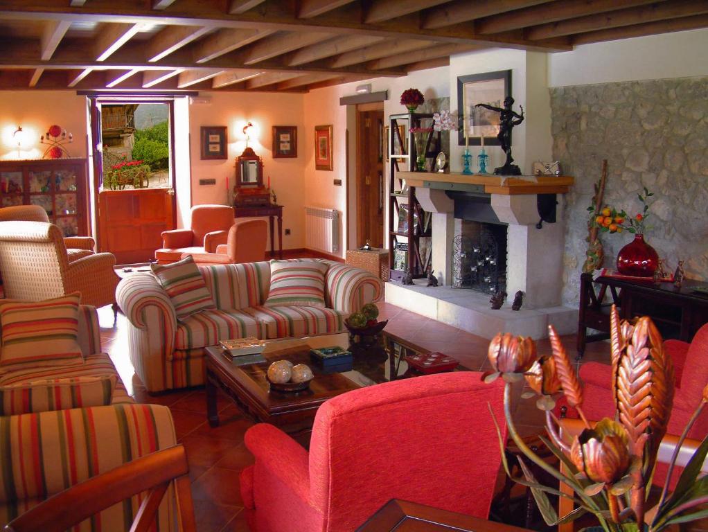 a living room with couches and a fireplace at Hotel Aldama Golf in Quintana de Llanes