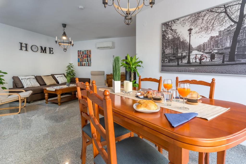 een eetkamer met een houten tafel en stoelen bij SF Carihuela Luxury Suite in Torremolinos