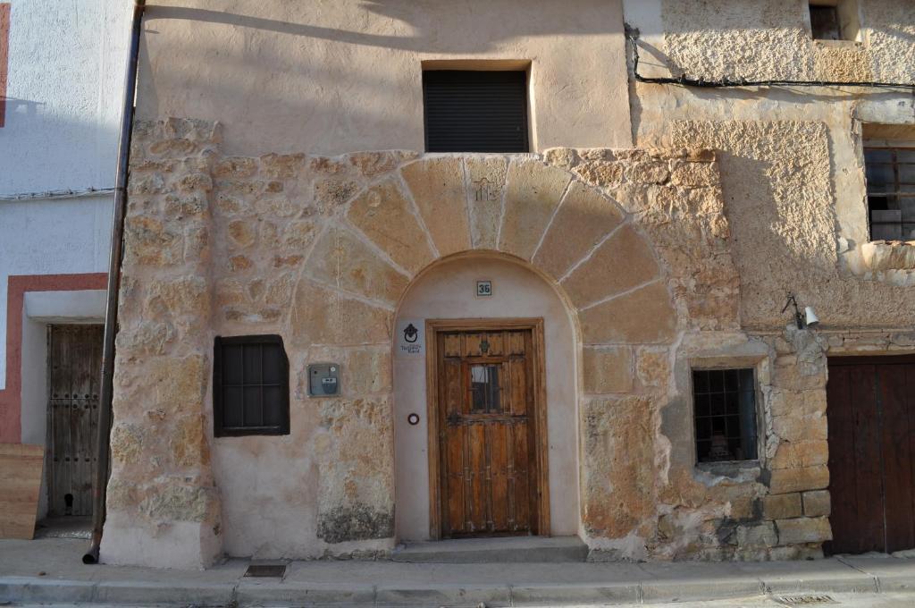 un antiguo edificio de piedra con puerta de madera en Casa Tolosa, en Las Cuerlas