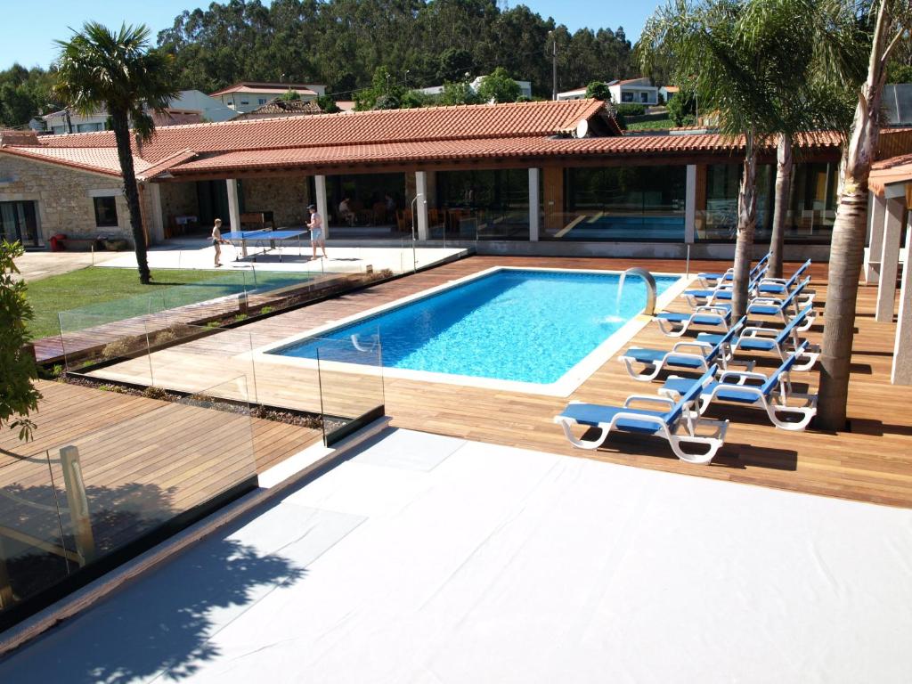 a swimming pool with lounge chairs next to a house at Villa Sole in Vila do Conde