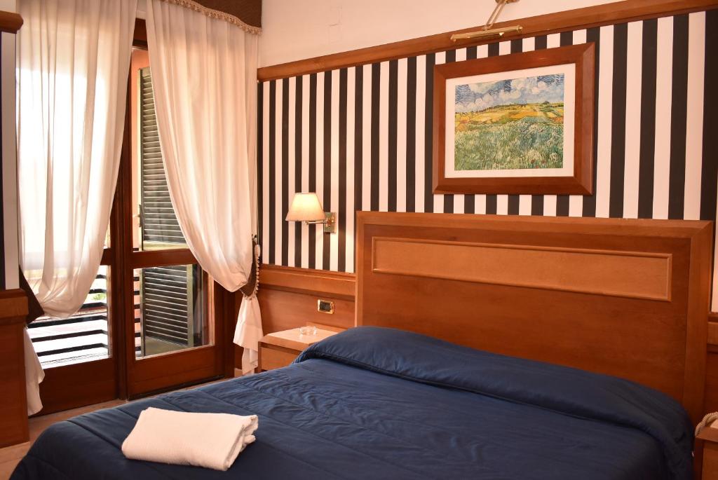 a bedroom with a blue bed and a window at Hotel Miravalle in Naples