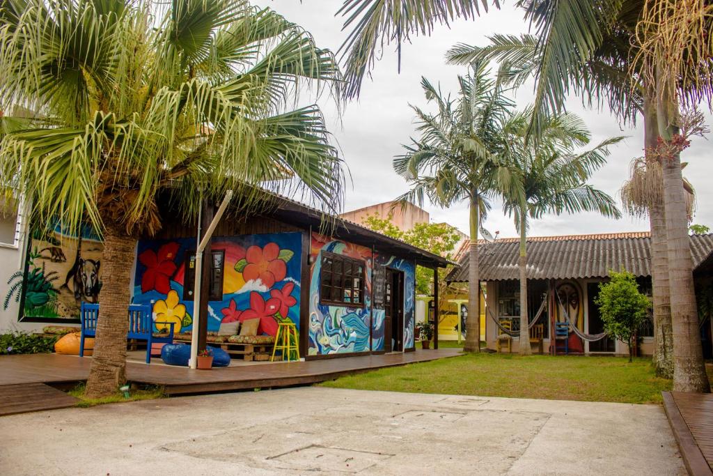 a colorful building with palm trees in front of it at Floripa Surf Hostel in Florianópolis