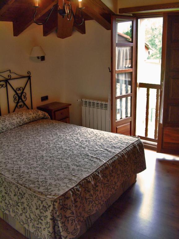 a bedroom with a bed and a large window at Hotel Aldama Golf in Quintana de Llanes