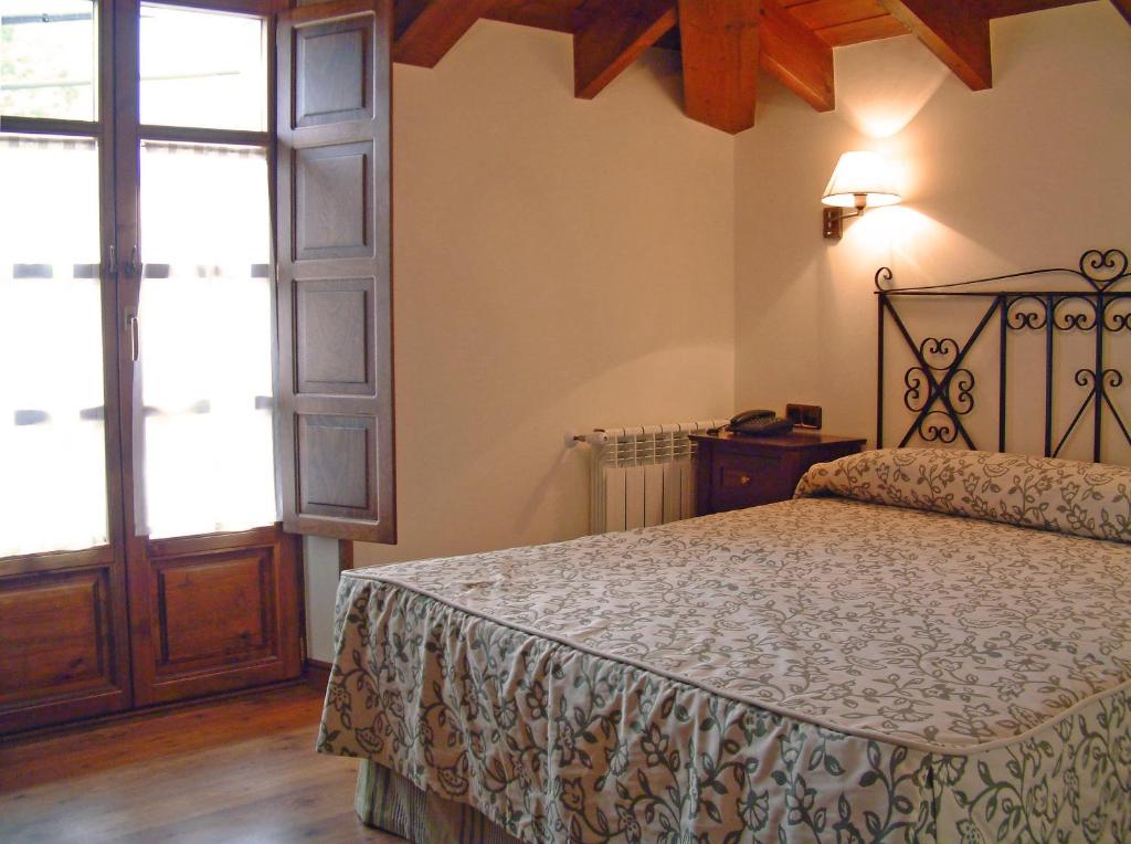 a bedroom with a bed and a large window at Hotel Aldama Golf in Quintana de Llanes