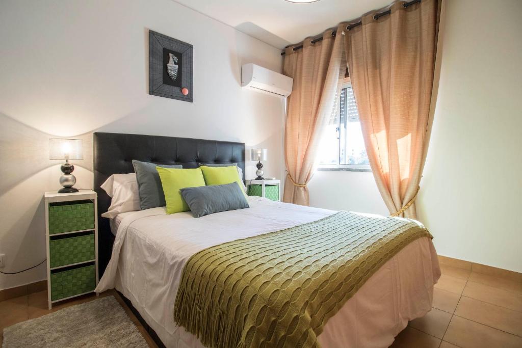 クアルテイラにあるBeach and Bliss in Algarveのベッドルーム1室(大型ベッド1台、黄色と灰色の枕付)