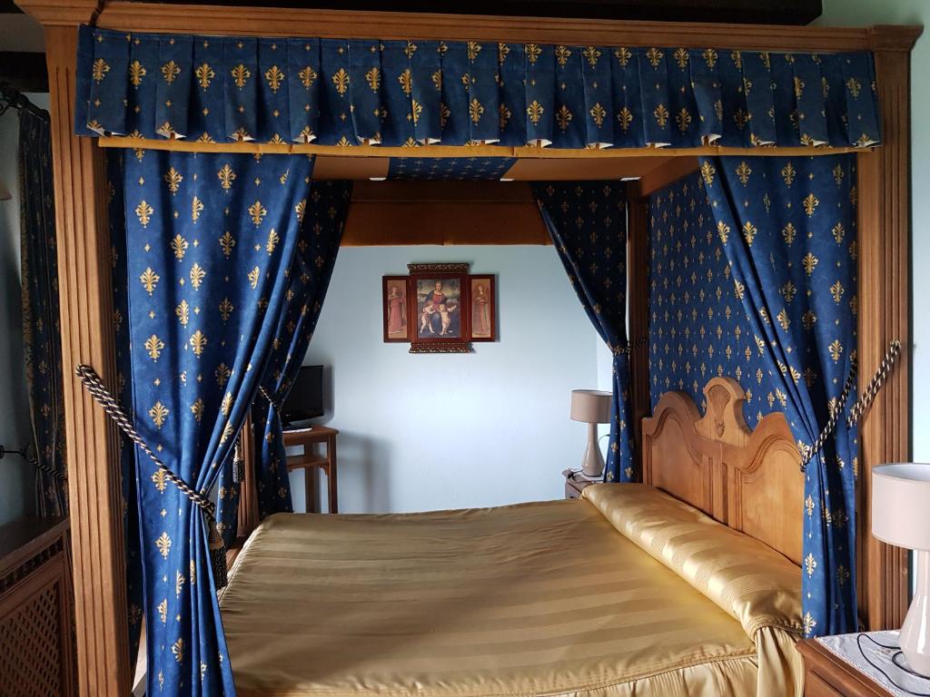 a bedroom with a canopy bed with blue curtains at Hotel Posada Real in Aínsa