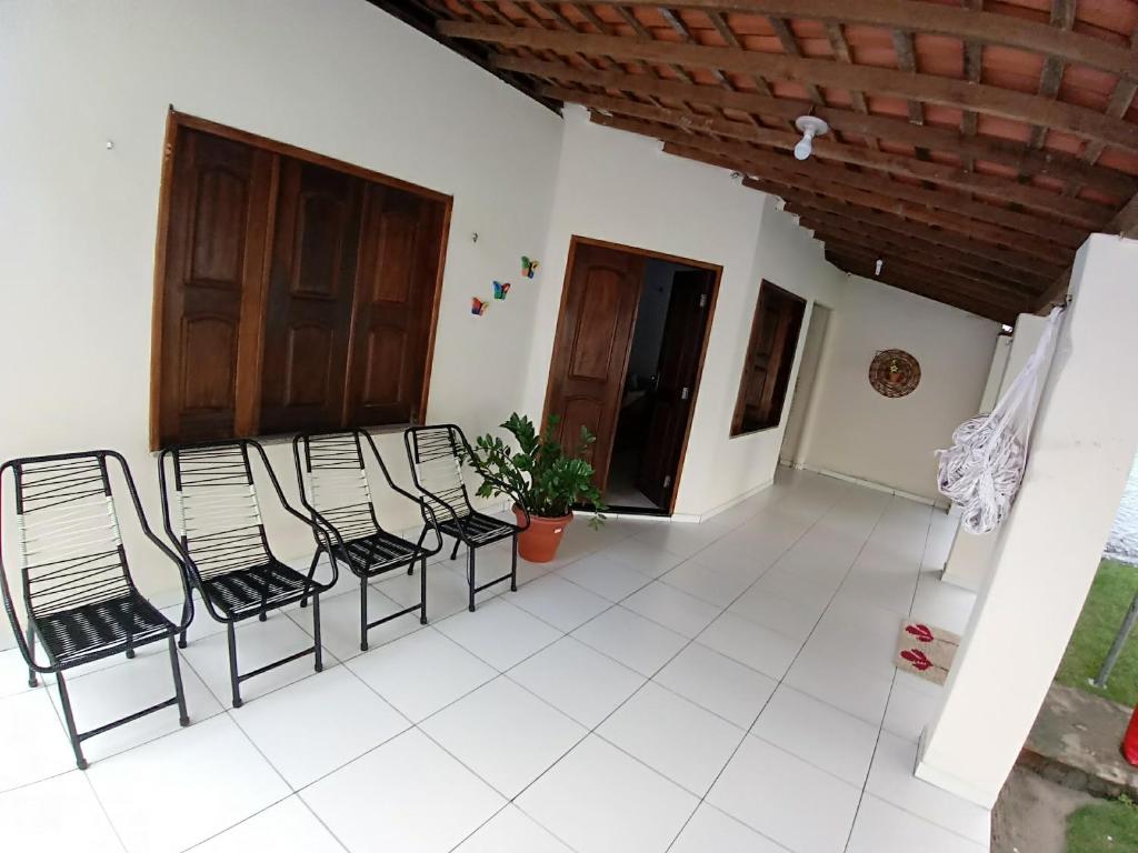 a group of chairs in a room with a porch at Casa Temporada com Ar cond e Wifi in Barreirinhas
