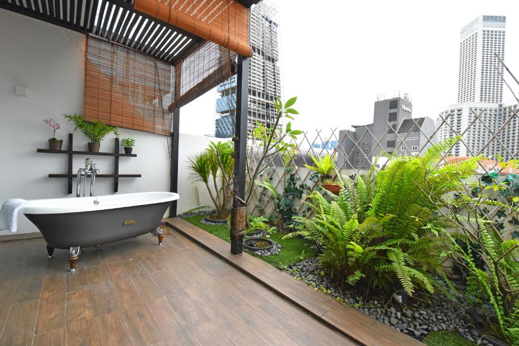 a bathroom with a bath tub on a balcony at Hotel NuVe Heritage in Singapore