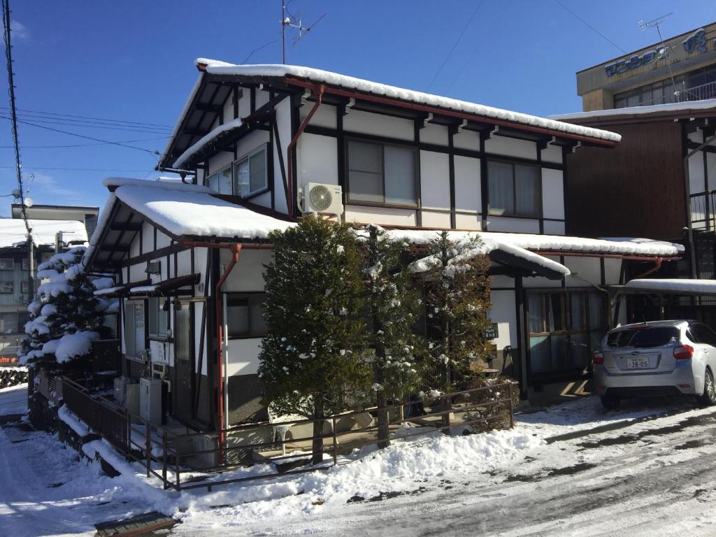 ein Haus mit einem Weihnachtsbaum davor in der Unterkunft Guest House Hinode in Takayama