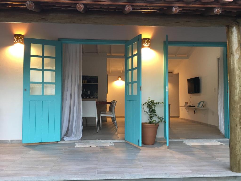 una camera con una porta blu e un tavolo di Vila dos Lençóis a Santa Cruz Cabrália
