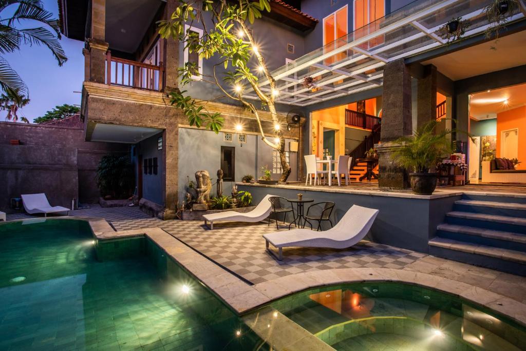 a house with a swimming pool and a patio at Laki Uma Villa - Male Only in Canggu