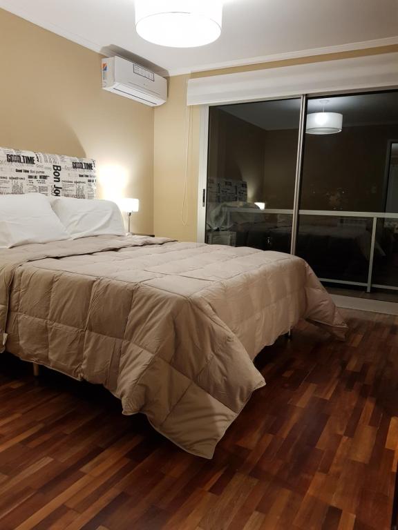 1 dormitorio con cama y ventana grande en Departamento Caseros Desing en Salta