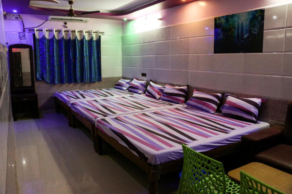 ein Schlafzimmer mit einem großen Bett mit Kissen darauf in der Unterkunft Sri Priya Lodge in Dharmapuri