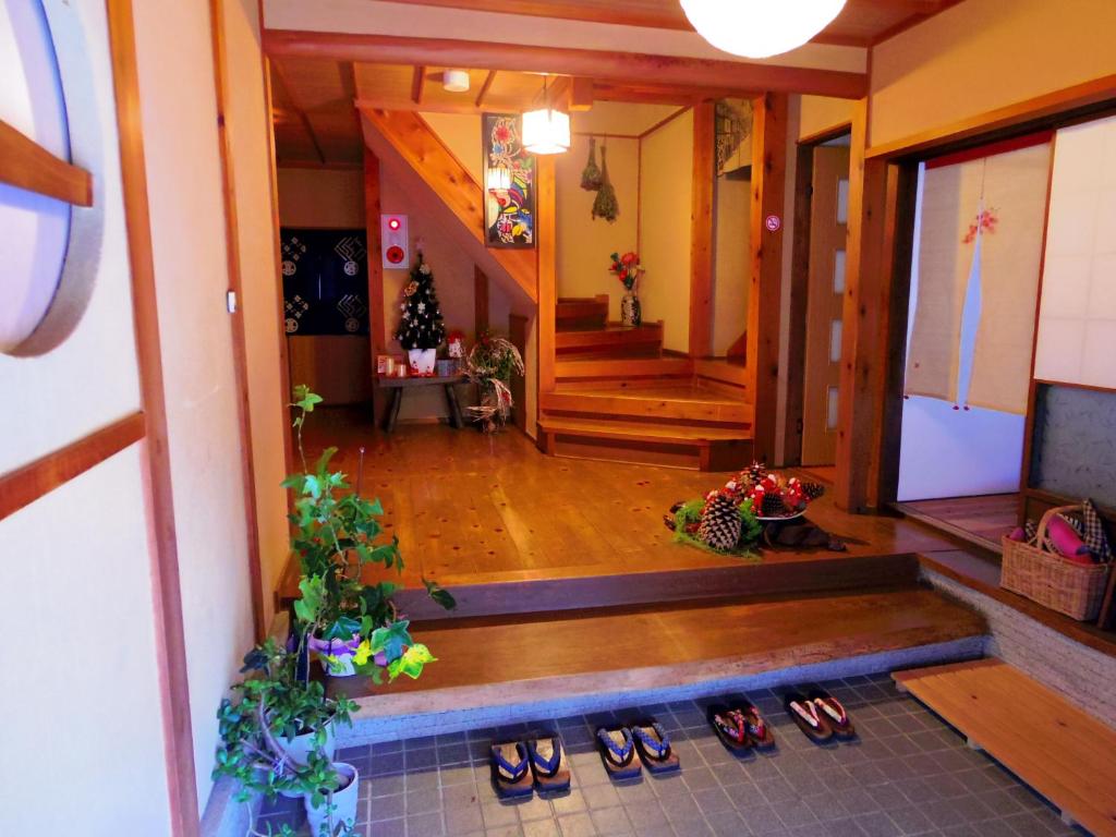 un pasillo con pares de zapatos en una casa en Guest House Motomiya en Nakatsugawa