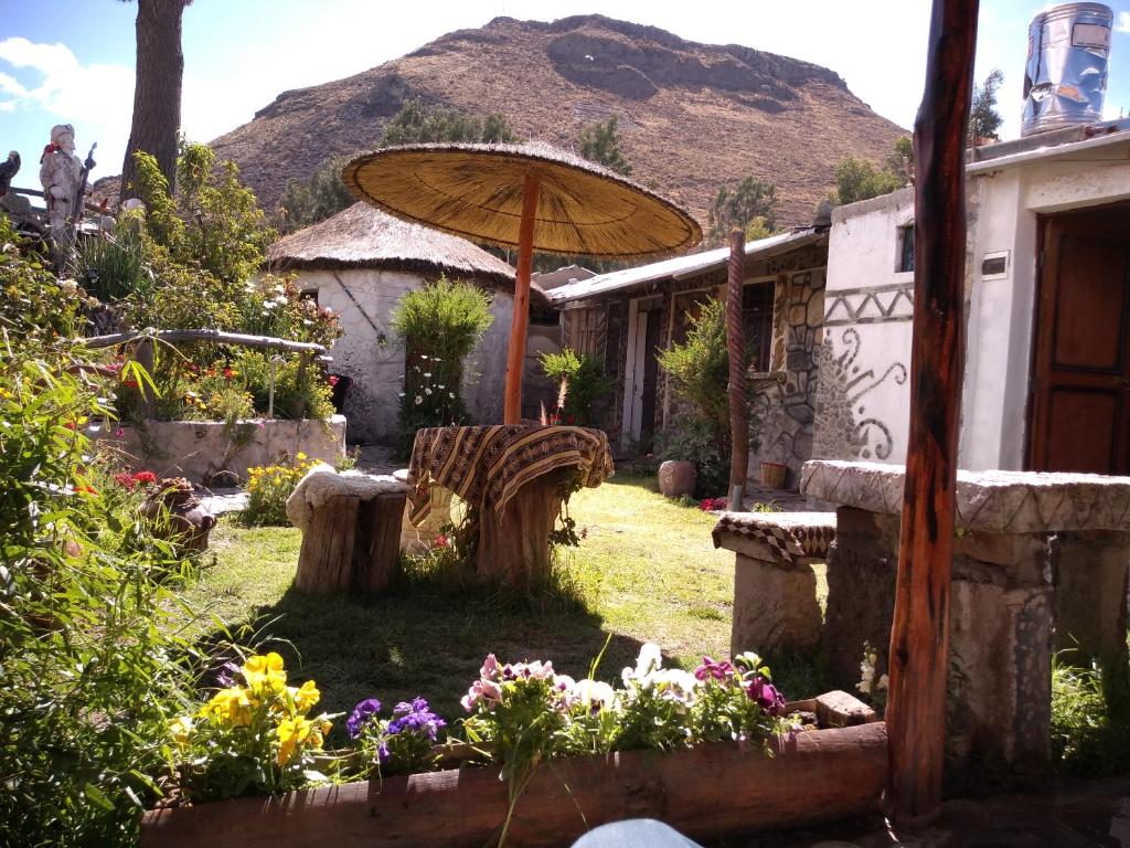 a garden with an umbrella and some flowers at Samana Wasi in Yanque