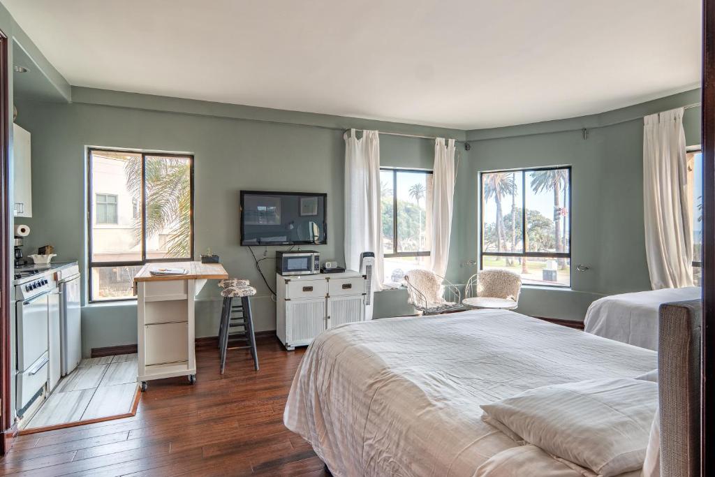 1 dormitorio con 1 cama, escritorio y 2 ventanas en Ocean Luxury Lofts and Suites, en Los Ángeles