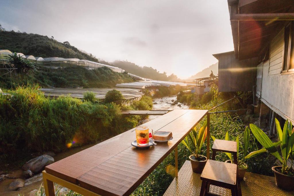 uma mesa de madeira com uma bebida em cima de uma varanda em Heahtitude - Children Not Allowed em Cameron Highlands