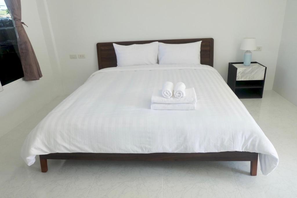 a bedroom with a bed with two towels on it at Airport Pearl Residence in Nai Yang Beach