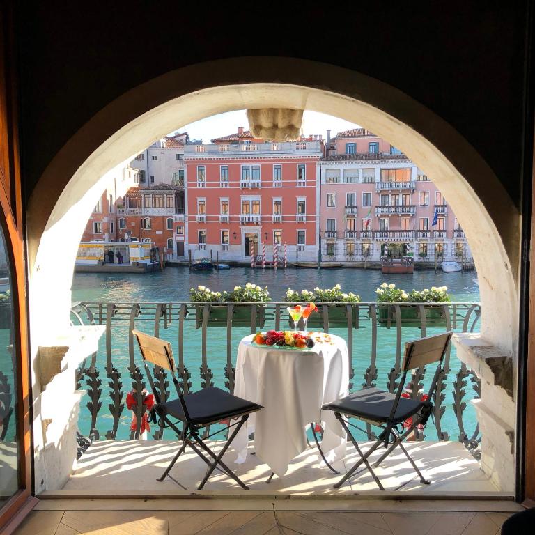 a table on a balcony with a view of the water at Hotel Palazzo Barbarigo Sul Canal Grande in Venice