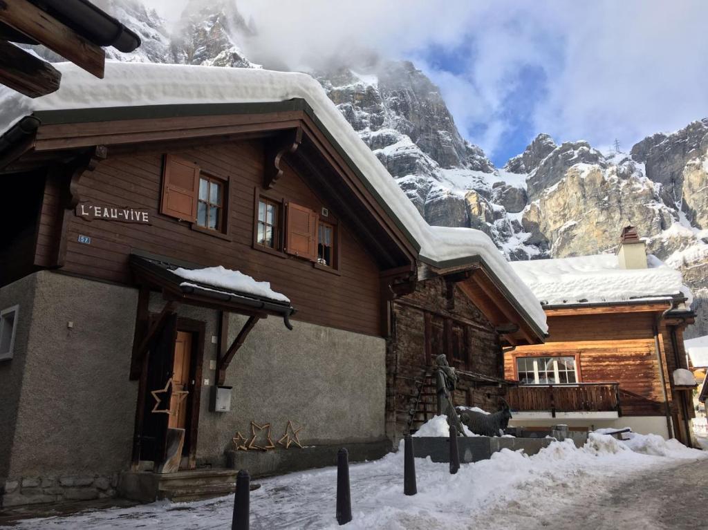 a house in the mountains with snow on the roof at L'Eau-Vive in Leukerbad