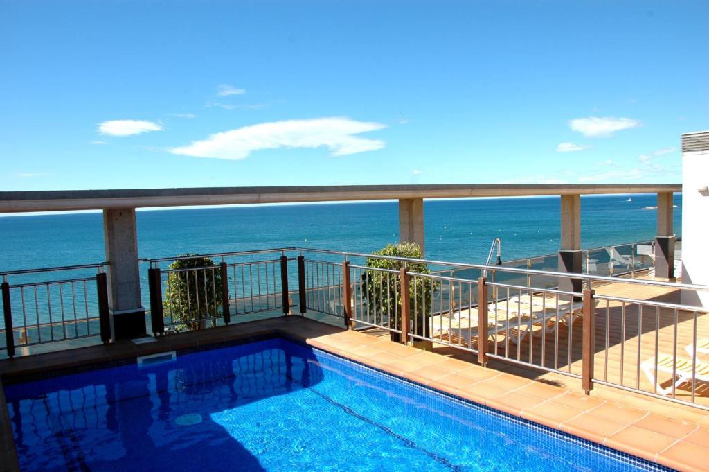 a balcony with a swimming pool and the ocean at Apartamentos las Palmas VII Family only in Salou