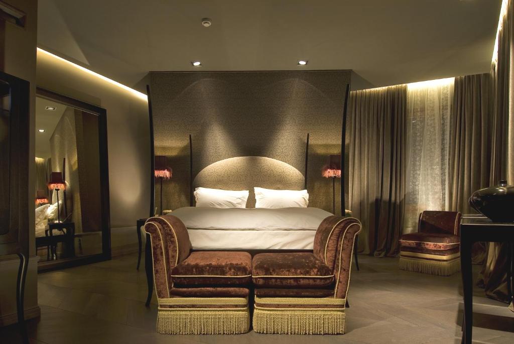 a bedroom with a bed and a chair in it at Hotel Palazzo Barbarigo Sul Canal Grande in Venice