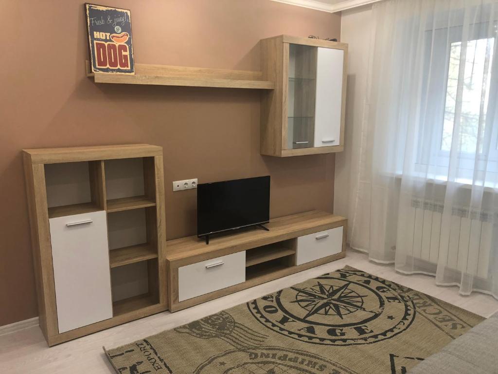 ein Wohnzimmer mit einem Entertainment-Center und einem Flachbild-TV in der Unterkunft GIL apartments, 38 Prospect Svobody in Uschhorod