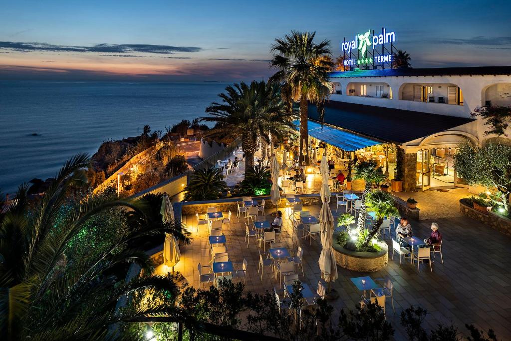an aerial view of a restaurant with the ocean at night at Hotel Terme Royal Palm in Ischia