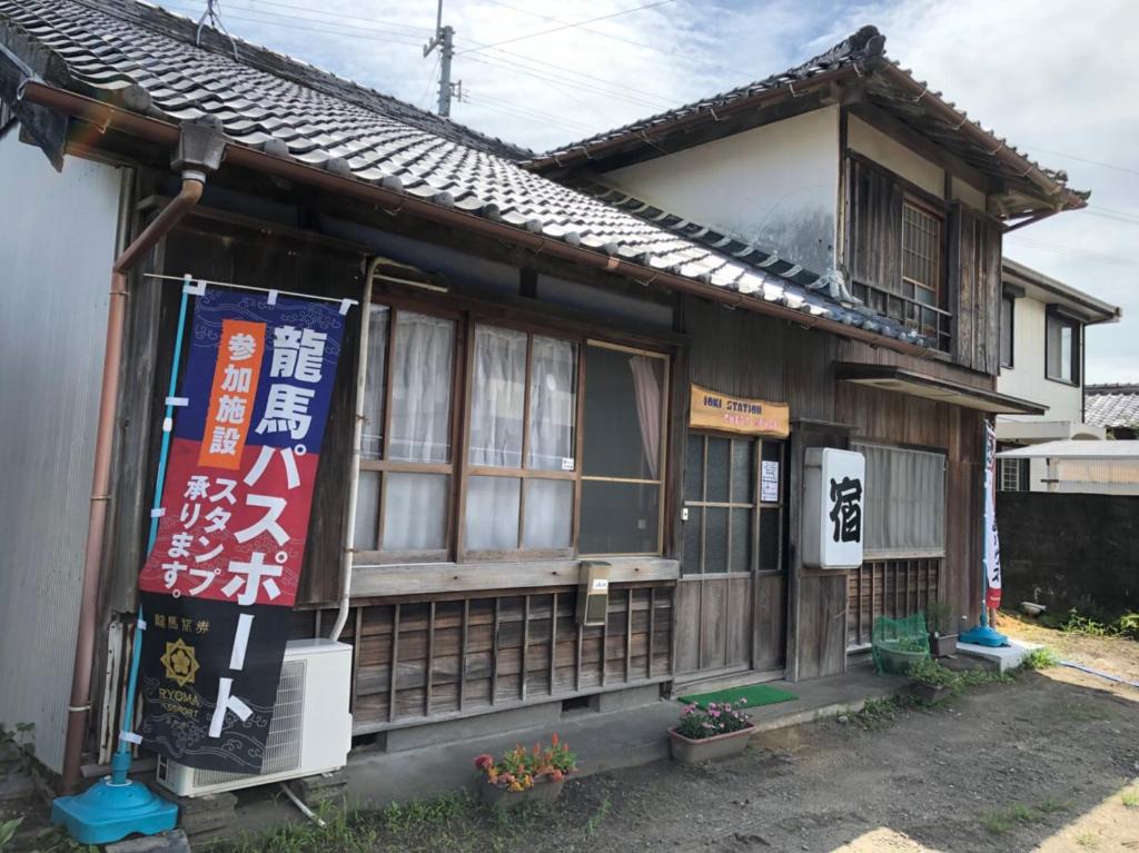Una casa con un letrero en la parte delantera. en Ioki Station Guest House, en Aki