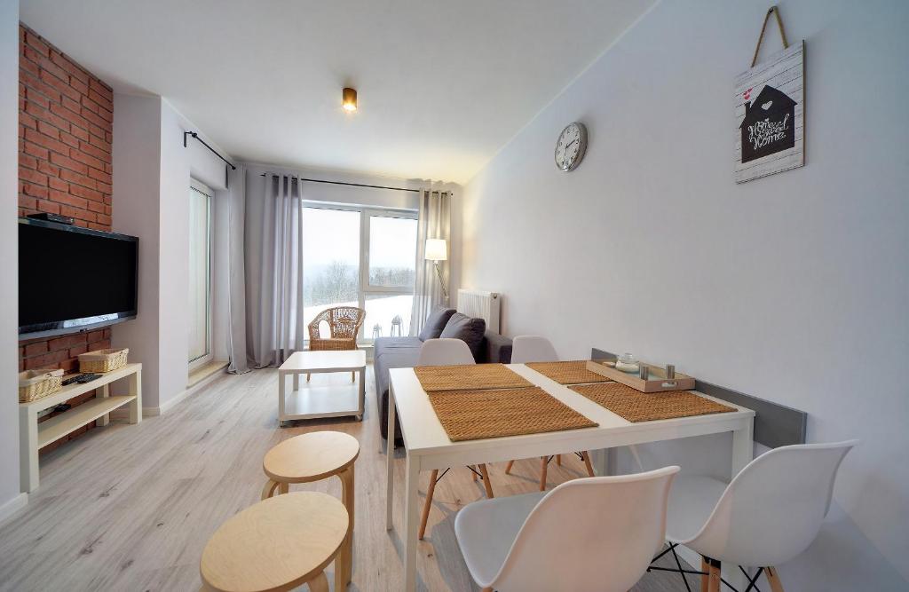 シュクラルスカ・ポレンバにあるApart-Invest Apartament Osloのリビングルーム(ダイニングルームテーブル、椅子付)