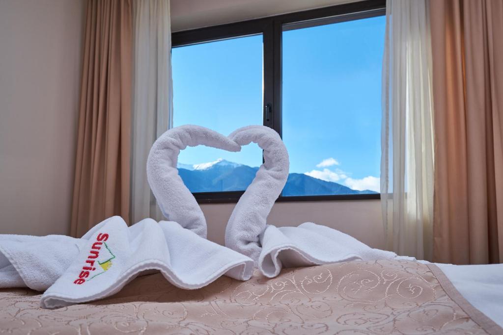 1 dormitorio con 2 toallas en forma de cisne en una cama en Sunrise Park Complex - Free Wellness, en Bansko