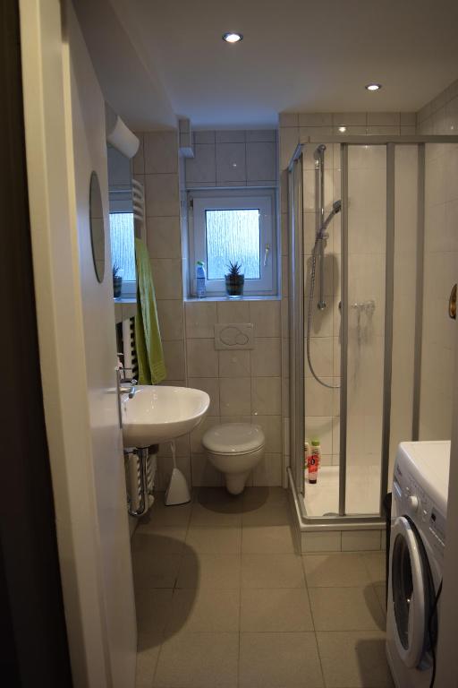 a bathroom with a toilet and a sink and a shower at Ferienwohnung Wörrstadt in Wörrstadt