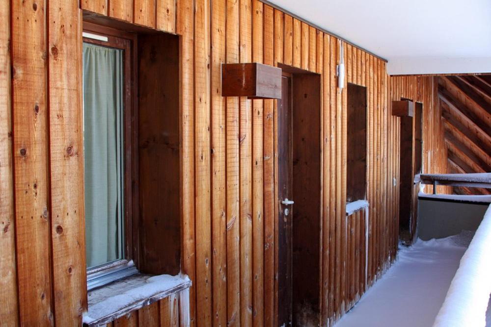 um quarto com paredes de madeira, 2 portas e uma janela em Epicea Avoriaz, three bedroom apartment, 4th floor, 8 to 10 ppl em Avoriaz