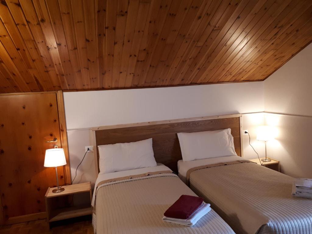 two beds in a room with wooden ceilings at B&B La Mansardina in Torri di Quartesolo