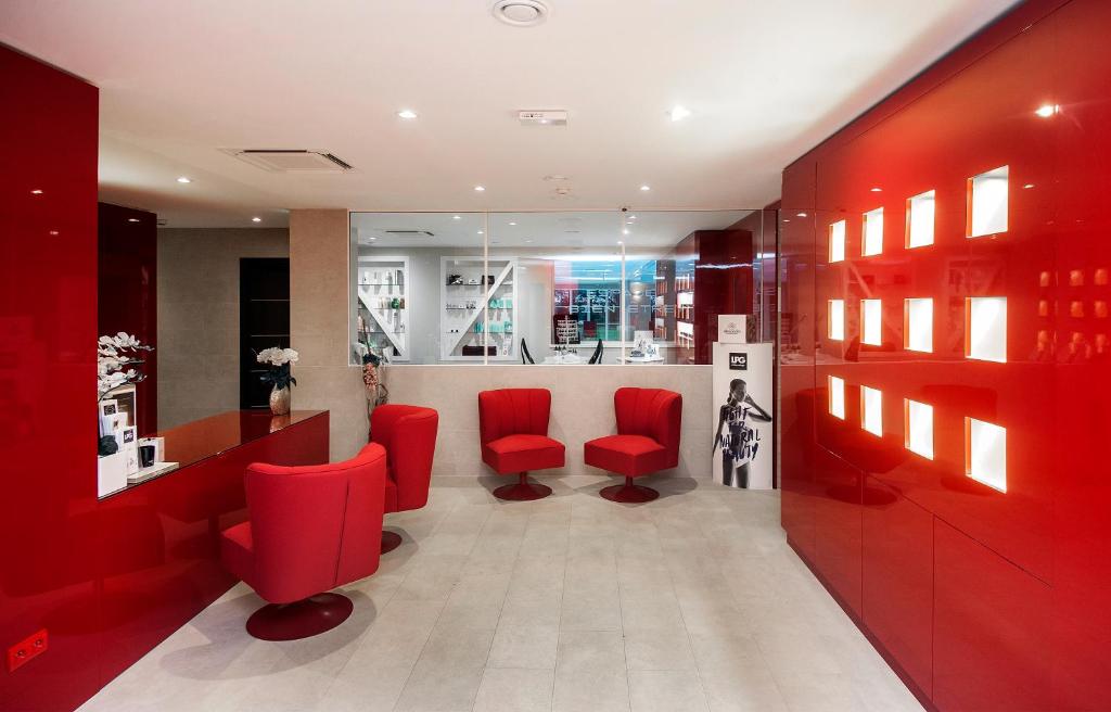 a red salon with red chairs and a waiting room at Le Grand Hôtel Le Touquet-Paris-Plage in Le Touquet-Paris-Plage