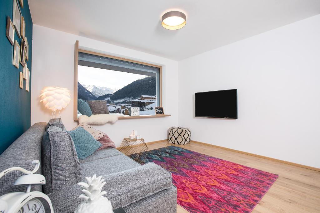 a living room with a couch and a flat screen tv at alpennest stubai in Neustift im Stubaital