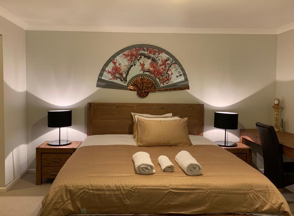 ein Schlafzimmer mit einem Bett mit zwei Handtüchern darauf in der Unterkunft Apple House Truganina in Truganina