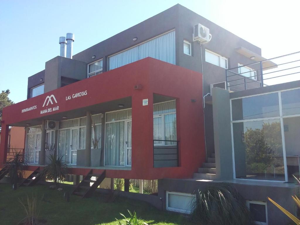 un bâtiment rouge avec un panneau à l'avant dans l'établissement Manadelmar, à Las Gaviotas