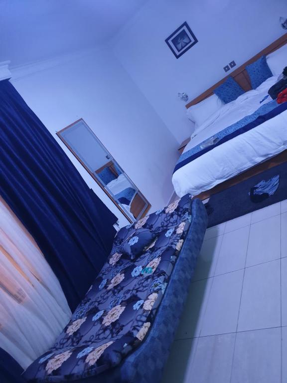 two beds in a hotel room with a bedskirts at H53 SUITES in Ikeja