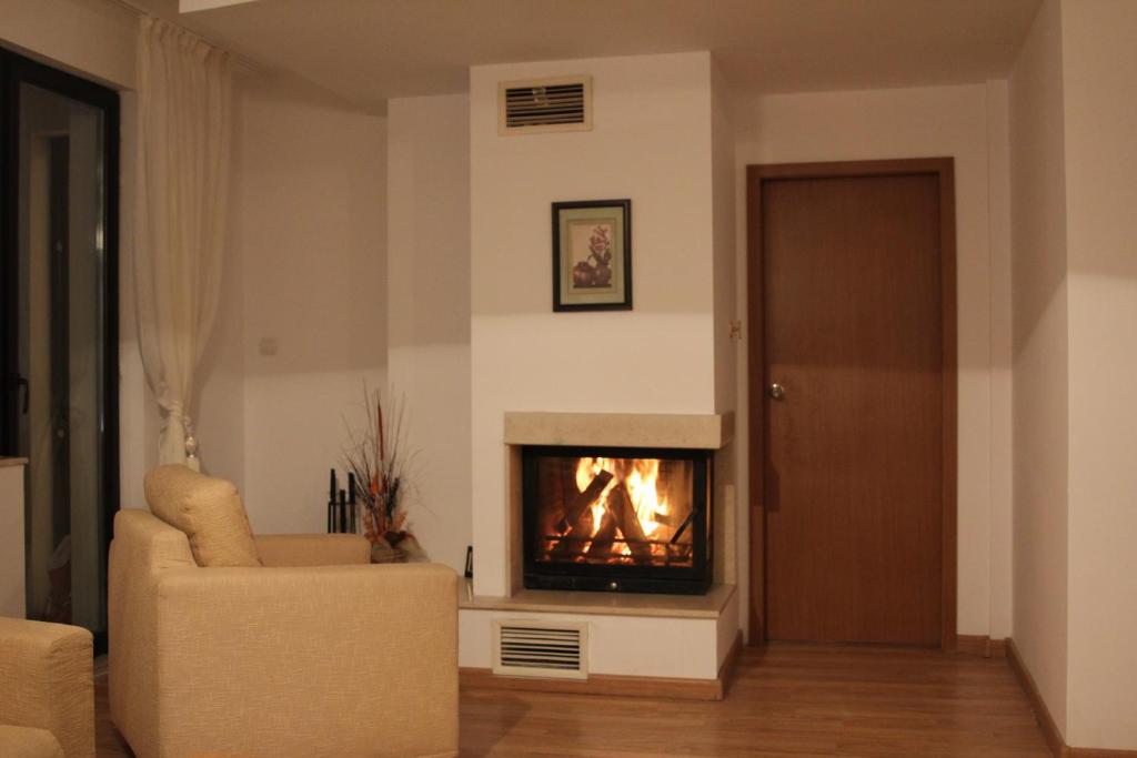 a living room with a fireplace and a couch at Apartment Svetla in Laplandia Complex in Pamporovo