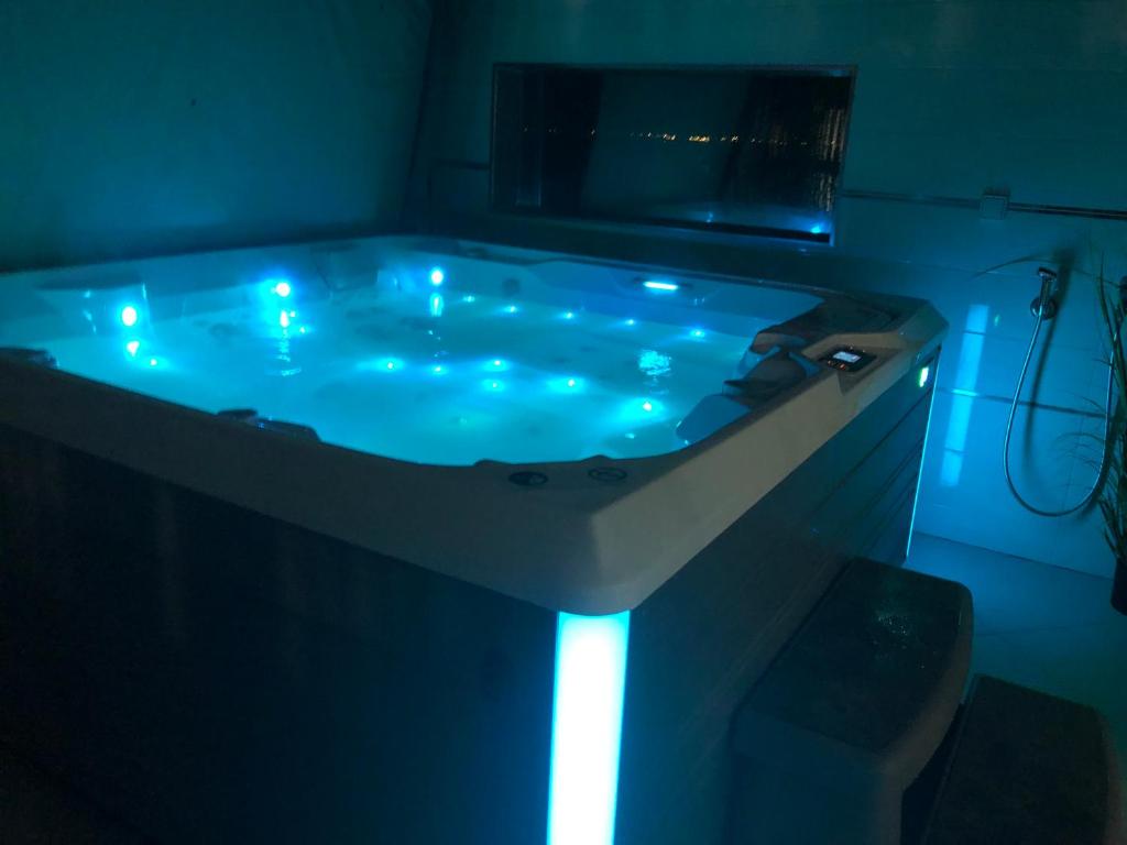 a bath tub with blue lights in a dark room at FLAMANTS ROSES 3 in Frontignan