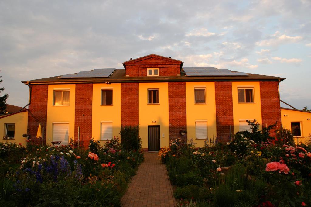 a large brick house with a pathway in a garden at Ferienwohnungen Amselweg in Brandenburg West