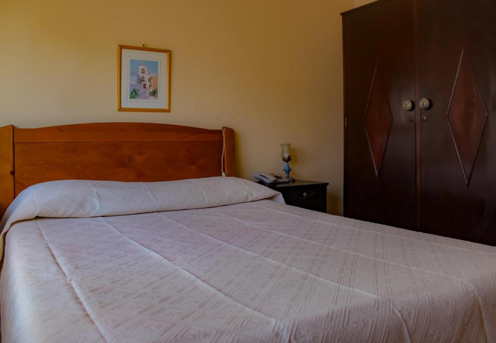 a bedroom with a bed and a dresser at Telhadense in Castelo Branco