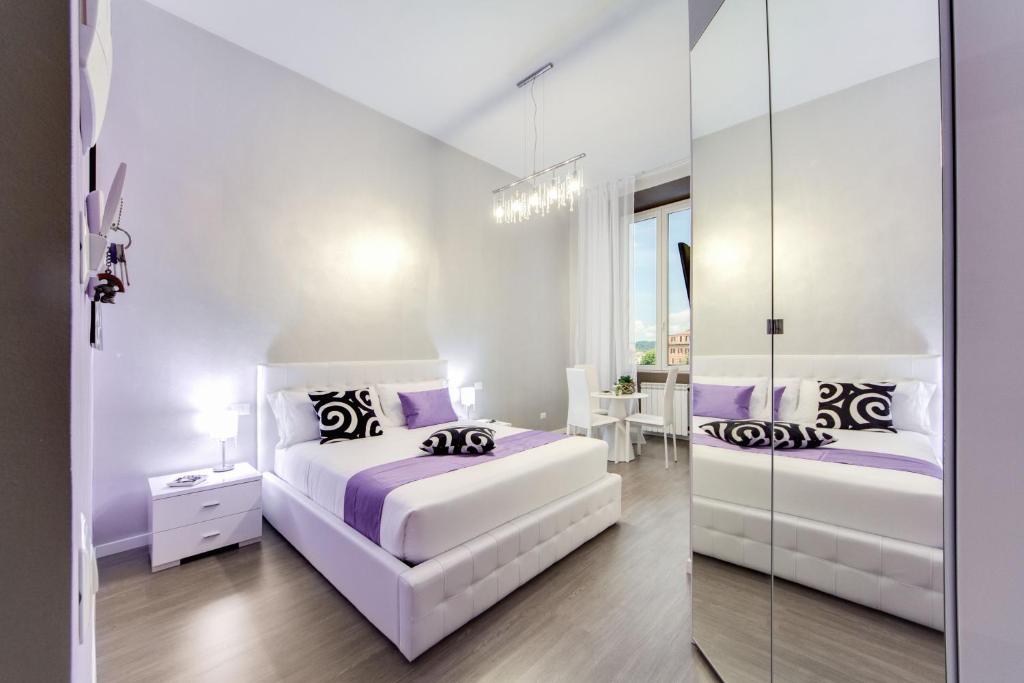 ローマにあるB&B Colosseo Panoramic Roomsの白いベッドルーム(ベッド2台、鏡付)