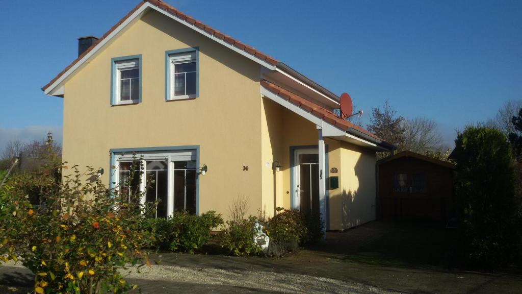 una casa gialla con un garage di fronte di Chalet Belair Schmidt a Dorum-Neufeld