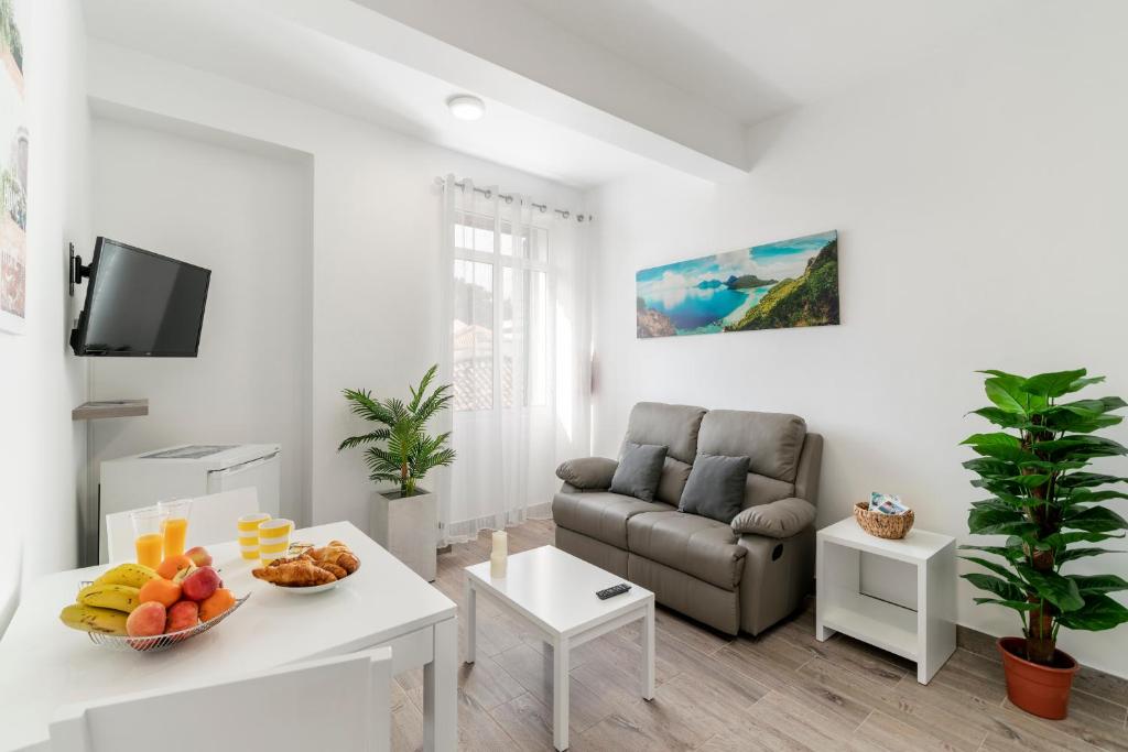a living room with a couch and a table with fruit at Funchal City Apartments in Funchal